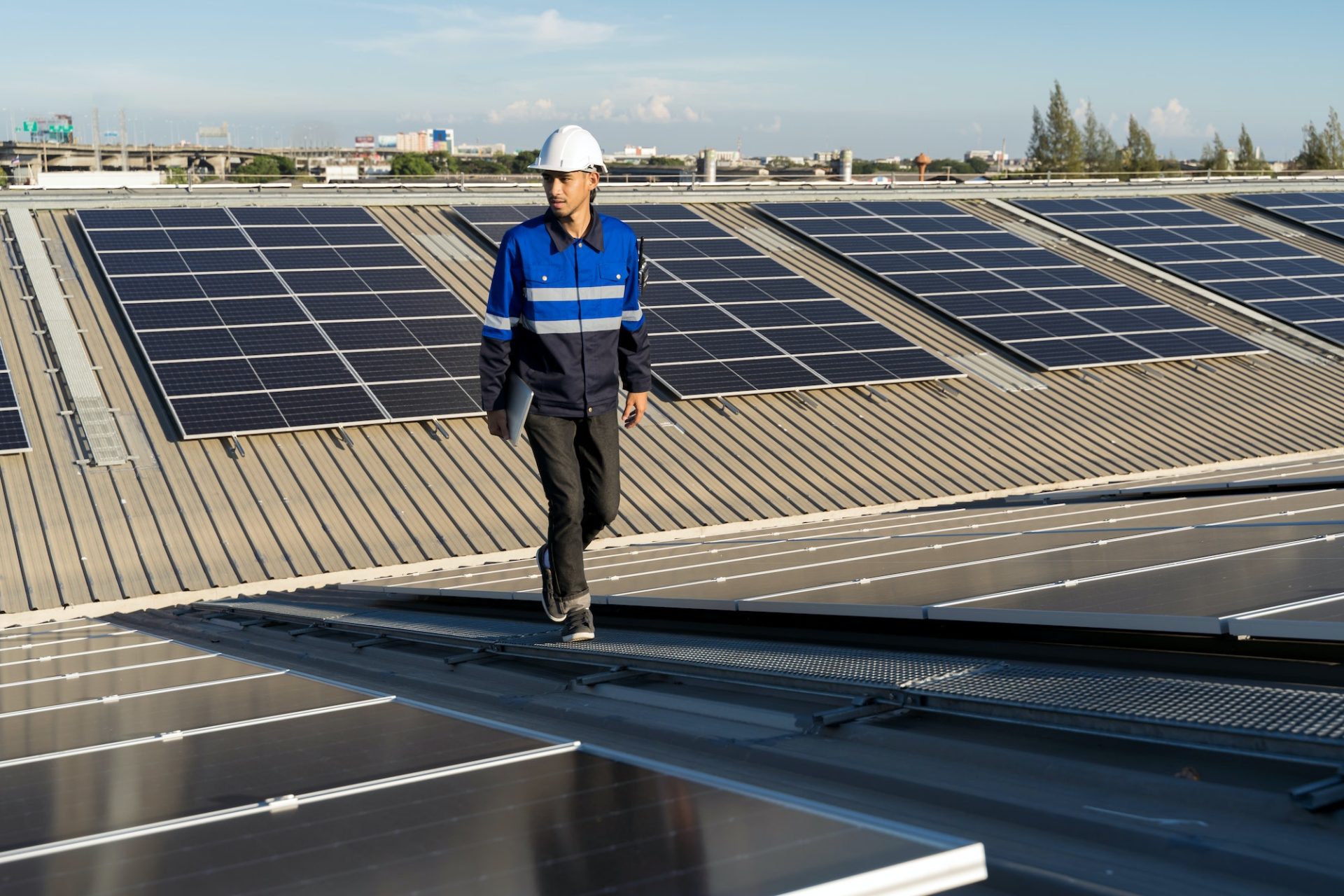 Asian technician installing inspection or repair solar cell panels solar cells on roof top factory