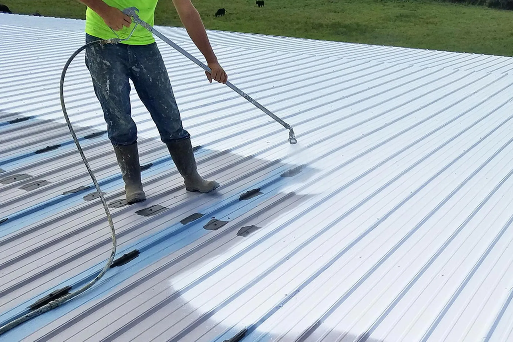 contractor-coating-and-sealing-a-metal-roof