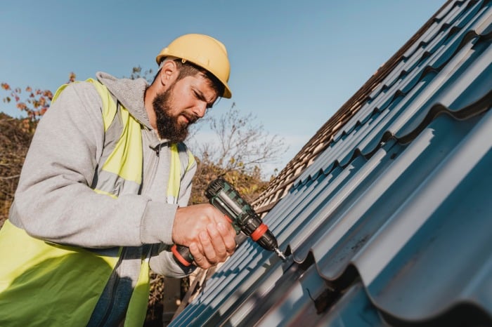 sideways man working roof with drill 1 1