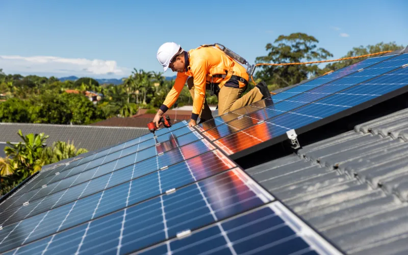 man installing solar panels on the roof