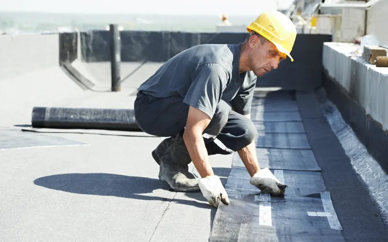 man replacing a flat roof