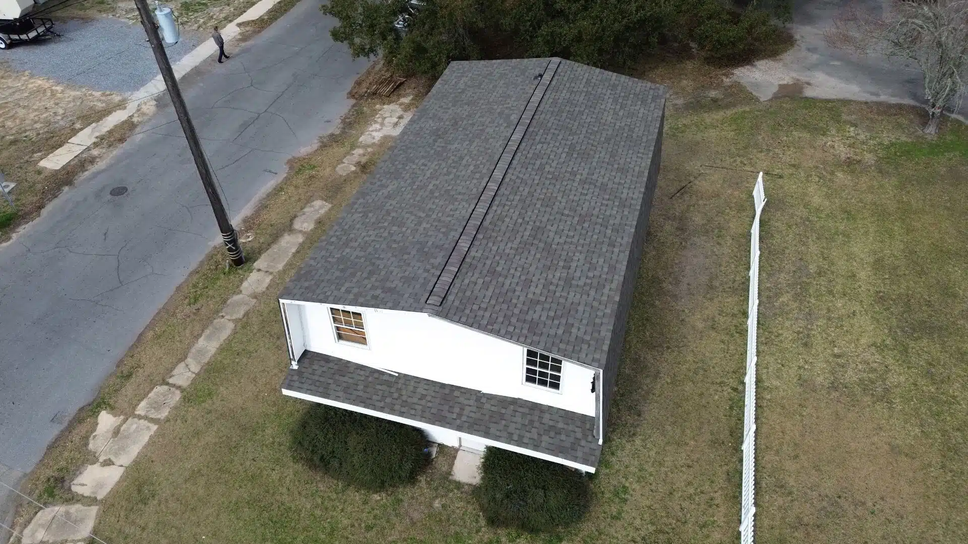 Asphalt shingle roof on a white Gulf Coast home installed by a roofing contractor in Gulfport MS, offering wind resistance up to 110 mph.