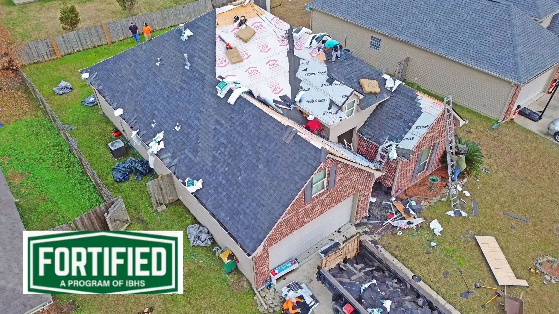 Aerial view of a fortified roof installation by Integrity Roofing during storm damage repair in Gulfport, MS. Discover cost insights in our blog: How Expensive Are Fortified Roofs?