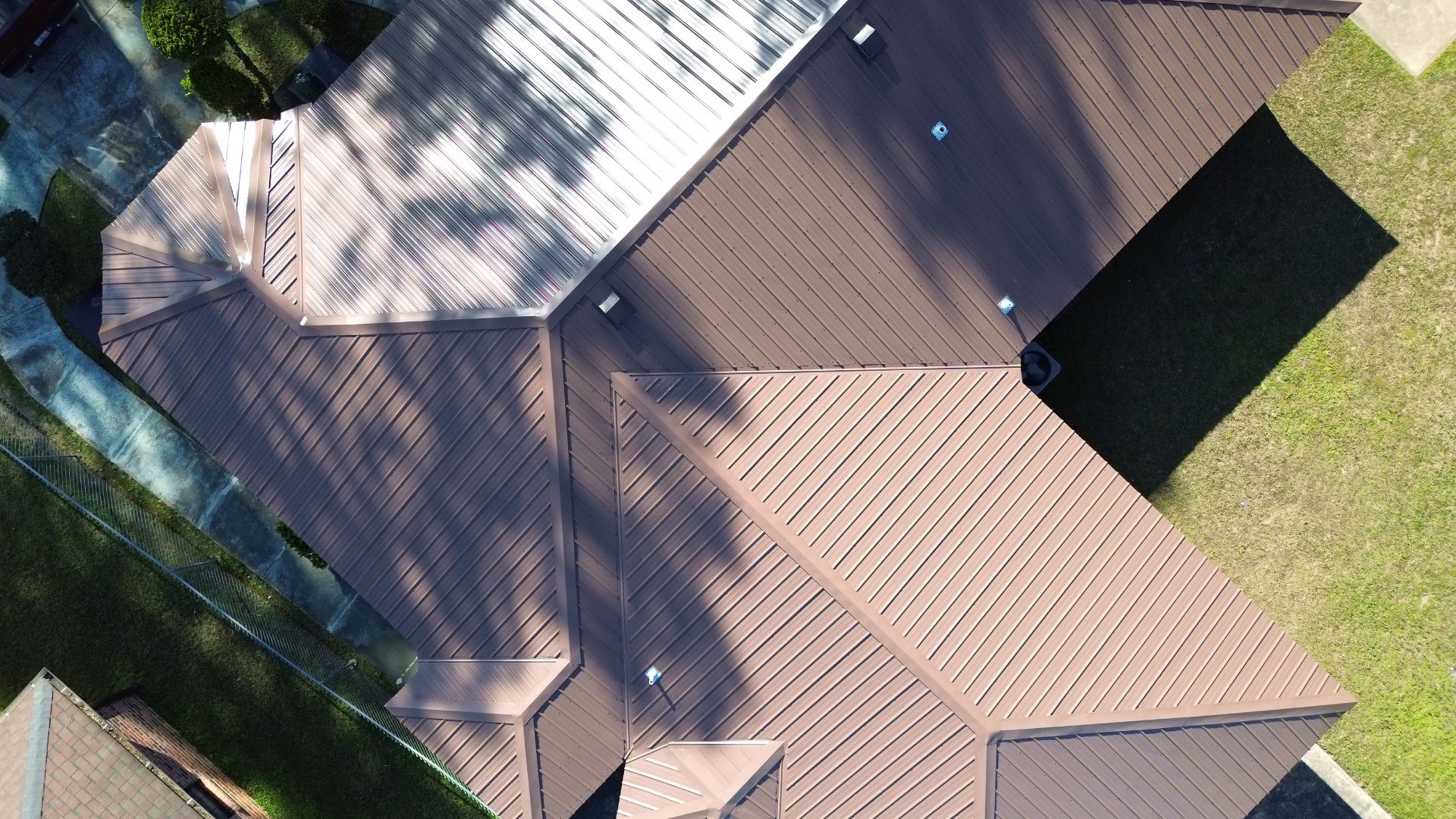 Metal standing seam roof installed on a brick house in the MS Gulf Coast region by a roofing contractor Gulfport MS, engineered to withstand 140–160+ mph winds.