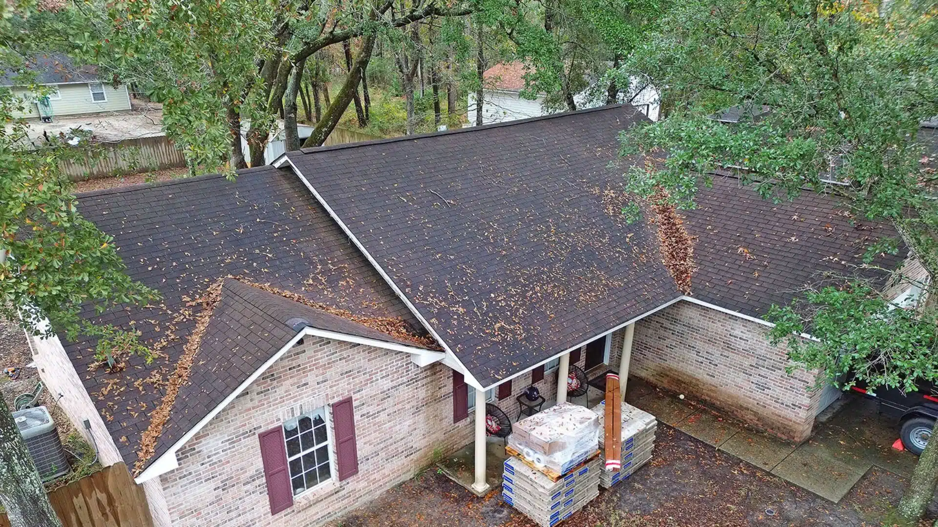 Aging Gulf Coast shingle roof showing typical granule loss and fading on a sunny slope.