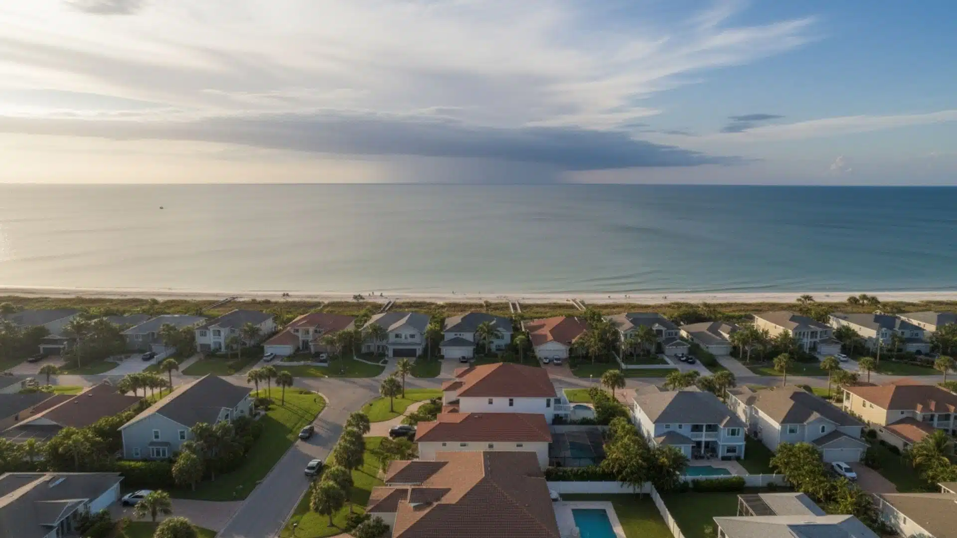 A fortified roof in Gulfport, MS standing strong under storm clouds while nearby homes show wind damage and blue tarps, symbolizing strength and resilience.