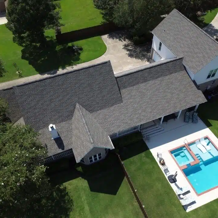 Aerial view of a home with a newly installed FORTIFIED Roof™ and backyard pool in Biloxi, Mississippi, demonstrating hurricane-resistant roofing protection.