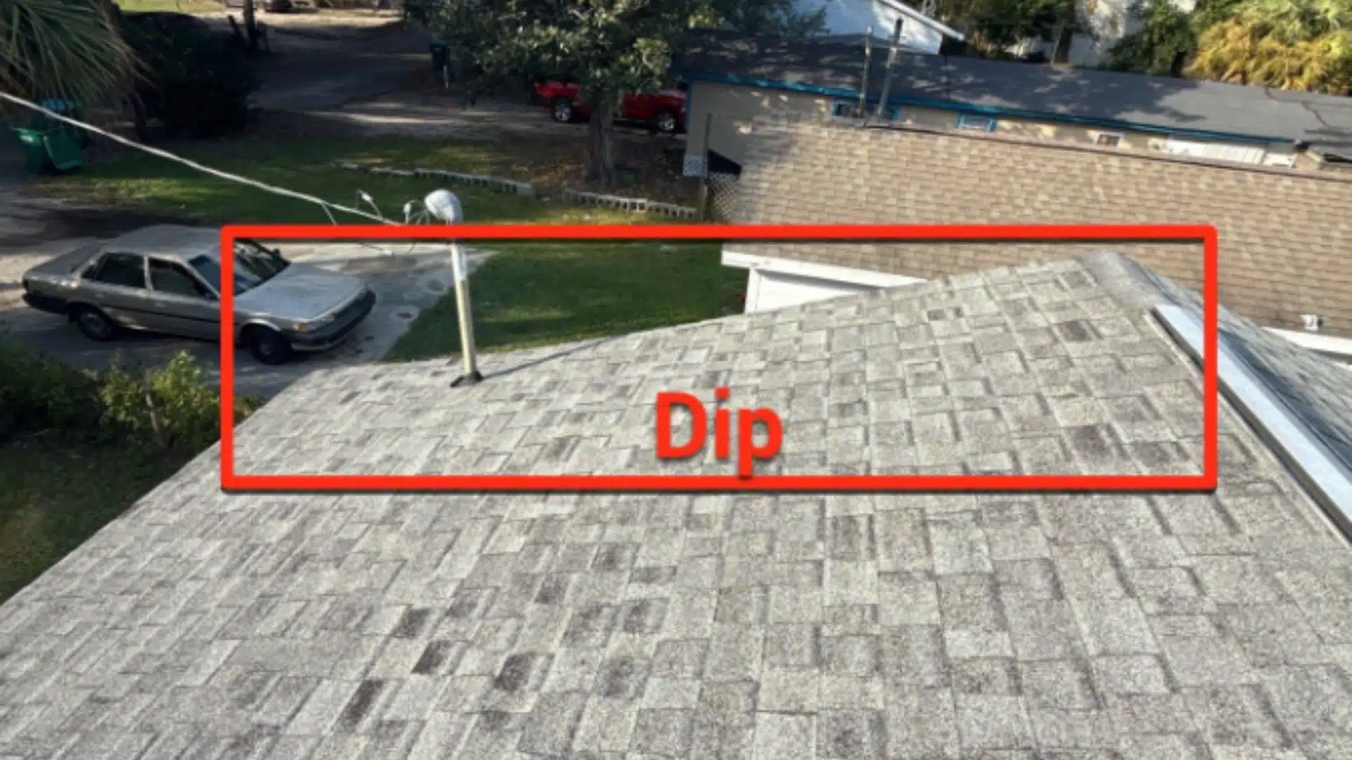 Sagging roof dip on asphalt shingles in Gulfport MS showing structural weakness and potential water pooling before heavy spring rain