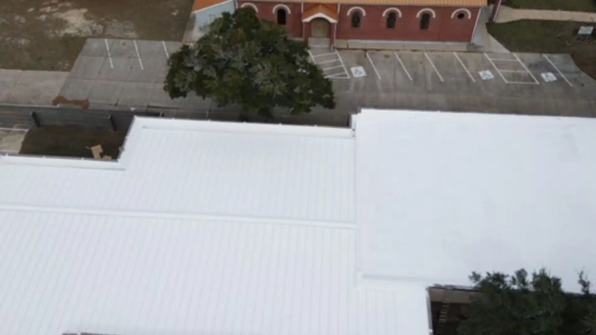 Aerial view of a commercial building in Gulfport, Mississippi featuring a white Duro-Last roofing system designed for energy efficiency and long-term weather protection.